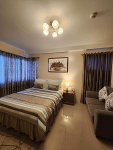 a bedroom with a bed and a couch at Condo , WIFI up to 100mbps , Infinity Pool in Cebu City