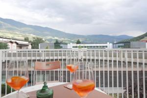 two wine glasses sitting on a table on a balcony at Stylish hideout - mountain view in Brixen