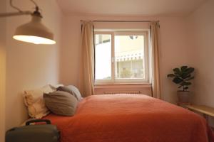 a bedroom with a bed with a window and a suitcase at Stylish hideout - mountain view in Brixen