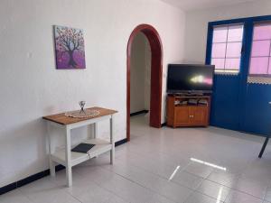 sala de estar con mesa y TV en Casa Leyna, en El Golfo