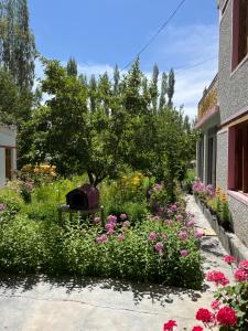 a garden with flowers in front of a building at Napishu Summer Home in Leh