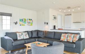 a living room with a couch and a table at Awesome Home In Ringkbing With 3 Bedrooms, Sauna And Wifi in Søndervig