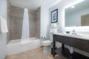 a bathroom with a sink and a toilet and a tub at Independence Stay Hotel and Long term suites in Houghton +12 photos