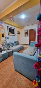 una sala de estar con sofás azules en una habitación en Hotel Valery II, en Huaraz