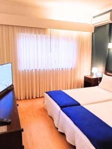 una camera d'albergo con letto e scrivania con computer di Corredoura Garden a Caldelas