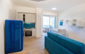 sala de estar con sofá azul y cocina en Pet Friendly Apartment In Pineto With Outdoor Swimming Pool, en Pineto