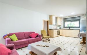 uma sala de estar com um sofá roxo e uma cozinha em 5 Bedroom Beautiful Home In Roda De Ber em Comarruga