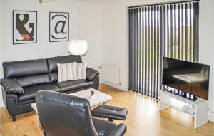 ThyborønにあるAmazing Home In Thyborn With Kitchenのリビングルーム(黒い革張りのソファ、テレビ付)
