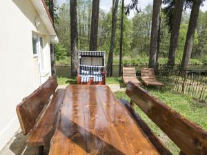 una mesa de picnic de madera con dos bancos en un patio en Ferienhaus Eldeblick direkt am Eldeufer in Parchim en Parchim