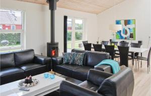 LoddenhøjにあるNice Home In Aabenraa With Kitchenのリビングルーム(黒革の家具、暖炉付)