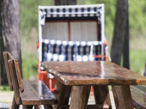 una mesa de picnic de madera y una silla en un parque en Ferienhaus Eldeblick direkt am Eldeufer in Parchim en Parchim