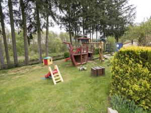 un patio con un parque infantil en el césped en Ferienhaus Eldeblick direkt am Eldeufer in Parchim en Parchim