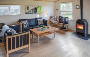 Sønder NissumにあるAwesome Home In Ulfborg With 3 Bedrooms And Wifiのリビングルーム(ソファ、薪ストーブ付)