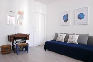 uma sala de estar com um sofá azul e uma secretária em Alfama Terrace Apartment em Lisboa