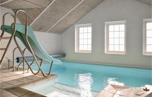 una piscina con tobogán en una habitación con ventanas en 5 Bedroom Gorgeous Home In Ringkbing en Ringkøbing