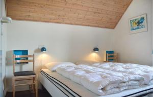 リンケビングにあるAwesome Home In Ringkbing With 5 Bedrooms, Sauna And Outdoor Swimming Poolの木製の天井のベッドルーム1室(大型ベッド1台付)