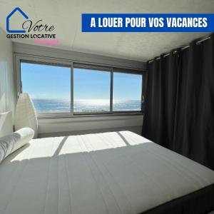 une chambre avec un lit et une grande fenêtre dans l'établissement Appartement vue mer 4 couchages, à Canet