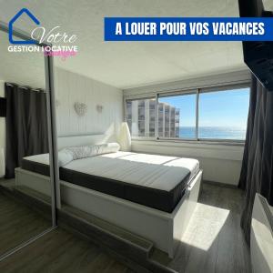 un lit dans une chambre avec une grande fenêtre dans l'établissement Appartement vue mer 4 couchages, à Canet