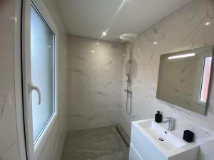 a white bathroom with a sink and a mirror at Maison moderne in Is-sur-Tille