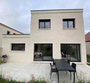 a house with a black table in front of it at Maison moderne in Is-sur-Tille