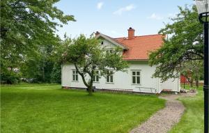 une maison blanche avec un arbre dans la cour dans l'établissement Awesome Home In deshg With Wifi, à Ödeshög