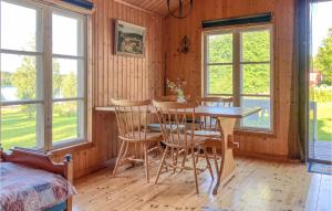 una sala da pranzo con tavolo, sedie e finestre di Lovely Home In Skellefte With Kitchen a Skellefteå