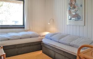 duas camas sentadas ao lado de uma janela num quarto em Nice Home In Hvide Sande With 3 Bedrooms, Sauna And Wifi em Nørre Lyngvig