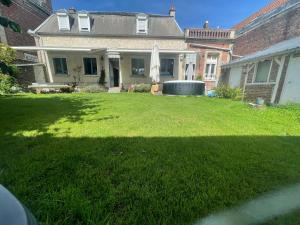 a yard with a large house with a large lawn at Chambre privée cosy in Noyon
