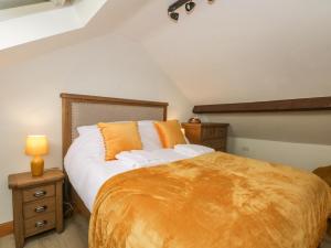a bedroom with a large bed with an orange blanket at Oak Tree View in Preston