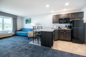 a kitchen and living room with a refrigerator and a couch at Independence Stay Hotel and Long term suites in Houghton