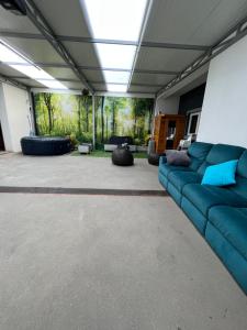 uma grande sala de estar com um sofá azul e cadeiras em BIG DREAMS Al em Vila do Conde