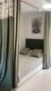 um quarto com uma cama de dossel e cortinas em Violeta em Los Urrutias
