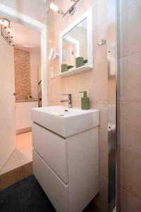 uma casa de banho branca com um lavatório e um espelho em Violeta em Los Urrutias