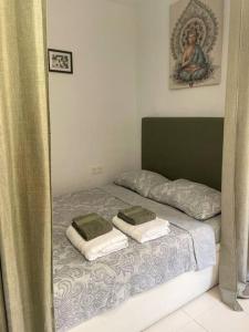 uma cama com duas toalhas em cima em Violeta em Los Urrutias