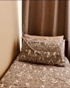 Cama con almohada y cabecera marrón en AC Lounge 36 (Room D), en Rochford
