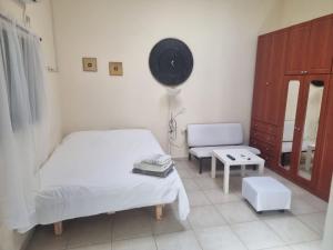 1 dormitorio con 1 cama, 1 silla y ventilador en B&B Amit 18 minutes from the airport - אירוח כפרי עמית 18 דקות משדה תעופה en Petaẖ Tiqwa