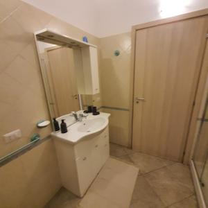 a bathroom with a sink and a shower with a mirror at Tranquillo alle porte di como con Box Auto in Malnate