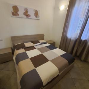 a bedroom with a bed with a checkered blanket at Tranquillo alle porte di como con Box Auto in Malnate