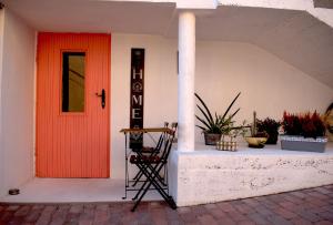 una puerta roja en un edificio blanco con plantas en Bakonyi Porta Olaszfalu, en Olaszfalu