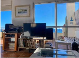 a living room with a tv and a large window at La caracola in Carboneras +15 photos