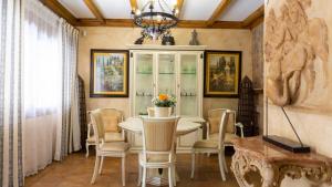 a dining room with a table and chairs and a chandelier at Mijas Beach House Parking in Mijas Costa