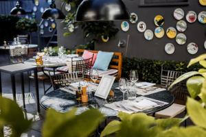 ein Restaurant mit Tischen, Stühlen und Tellern an der Wand in der Unterkunft Romantikhotel Rebstock art & design in Kehl am Rhein