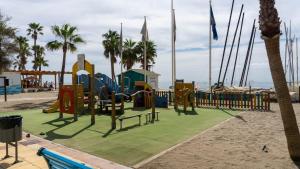 Un parque infantil en la playa con palmeras en Mijas Beach House Parking, en Mijas Costa