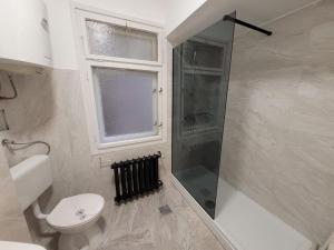 a bathroom with a shower and a toilet and a window at HelloZagreb Apartment in Zagreb
