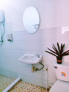 ein Badezimmer mit einem Waschbecken, einem WC und einem Spiegel in der Unterkunft 天堂鸟花园客栈 in Luang Prabang