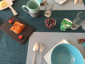 una mesa con un plato de comida y un tazón de bayas en La douceur Saumuroise avec petit déjeuner, en Saumur
