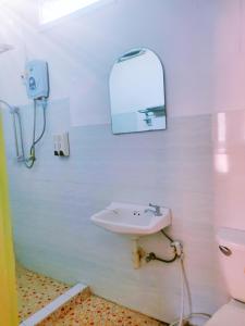 ein Bad mit einem Waschbecken und einem WC in der Unterkunft 天堂鸟花园客栈 in Luang Prabang
