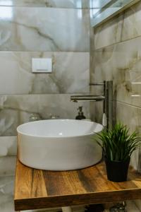 a white sink on a wooden table in a bathroom at Vila K2 in Vrdnik