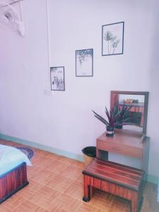 1 dormitorio con cama, mesa y espejo en 天堂鸟花园客栈, en Luang Prabang