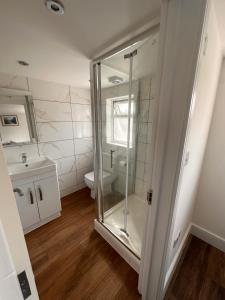a bathroom with a glass shower and a toilet at Lovely Hillingdon Family Holiday Home - 7 bedrooms in Ickenham